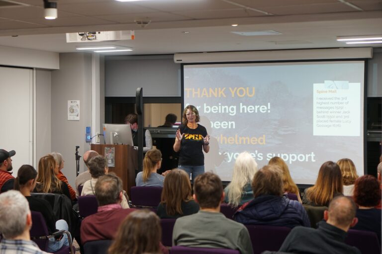 Speaker addressing a seated audience at the end of a presentation