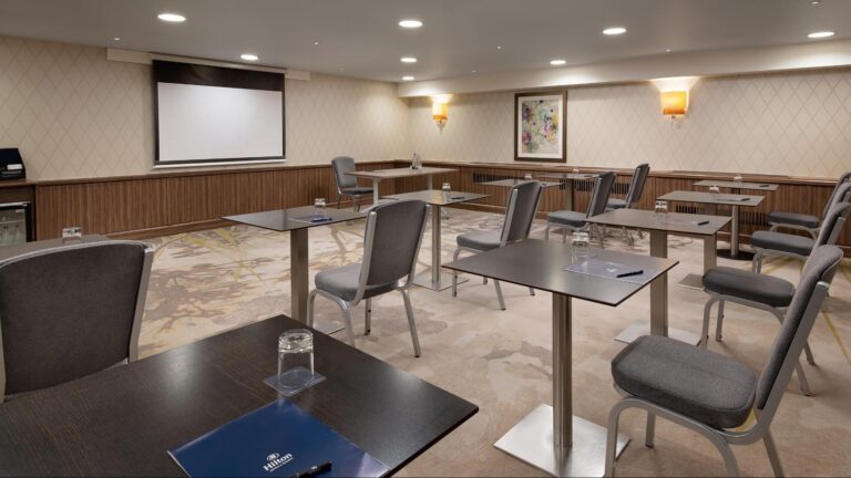 Kensington Room with small breakout tables set with delegate folders