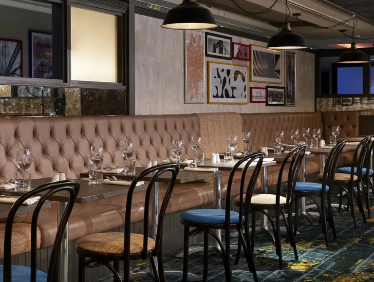 Leo's Restaurant dining area with leather booths and a gallery of framed art