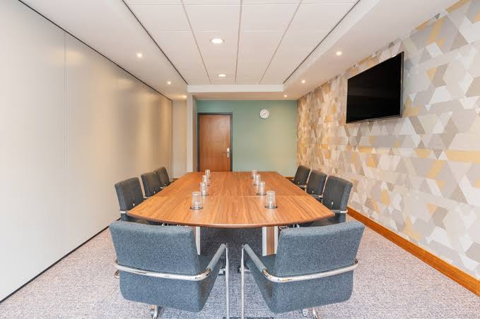 Locomotion Suite oval table set boardroom-style with a wall screen