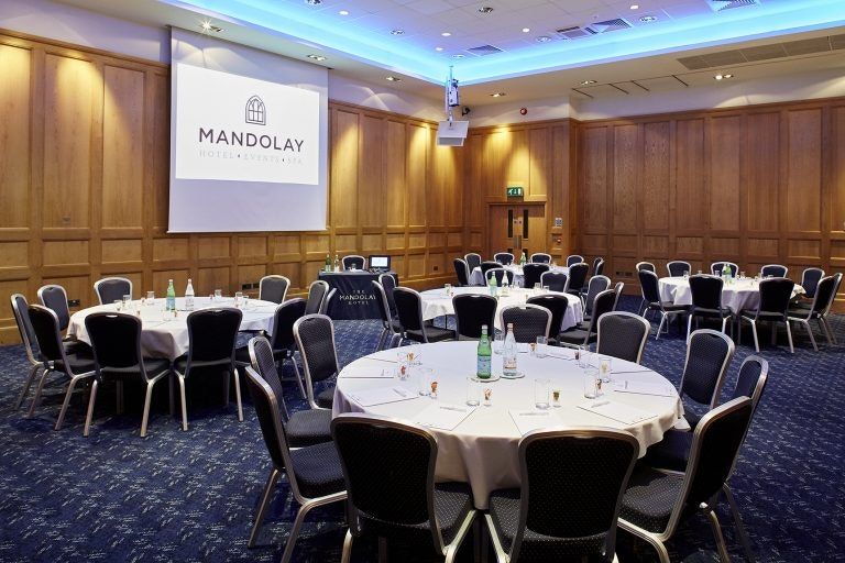 Pewley room set cabaret-style with round tables and wood panelling