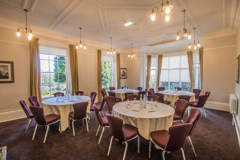 Private dining room with round tables and purple upholstered chairs