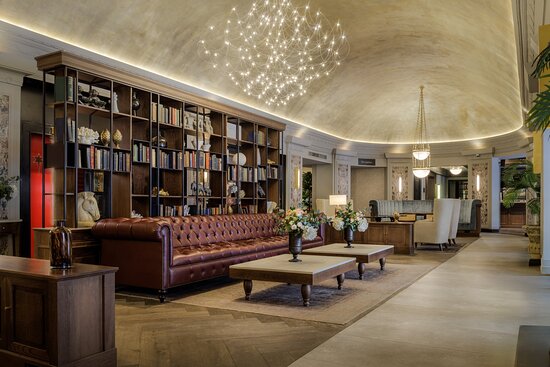 Scene lobby bar with a leather chesterfield sofa, bookshelves and a domed ceiling.