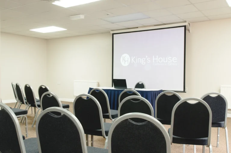 Seminar room set classroom-style with rows of chairs facing a screen