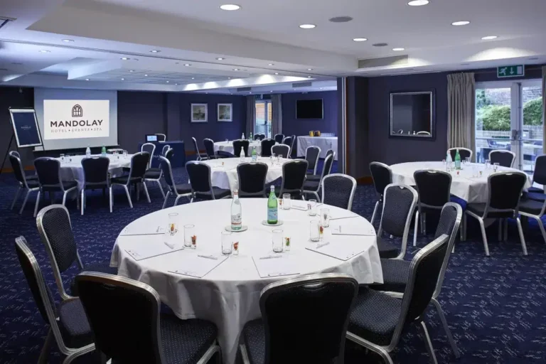 Surrey Suite set cabaret-style with round tables and a wall-mounted screen