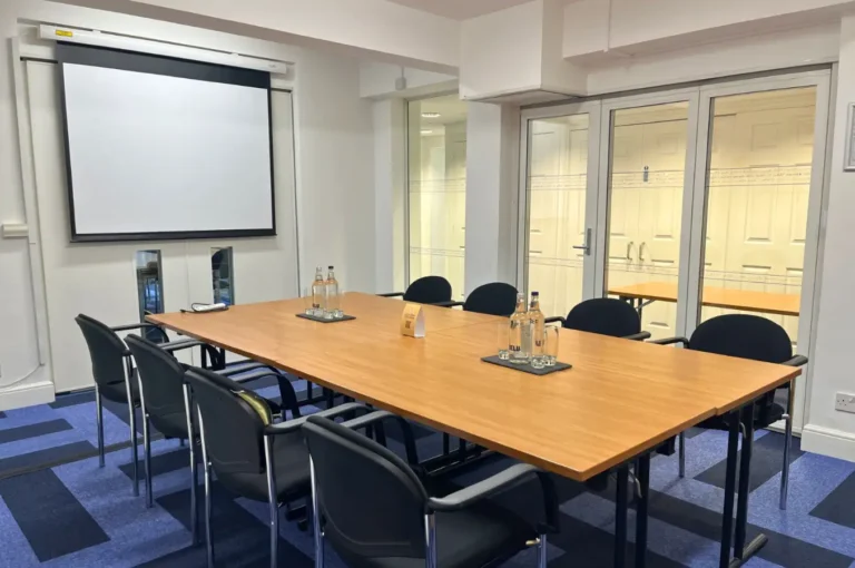 Sylvester Room with a boardroom table facing a pull-down projector screen