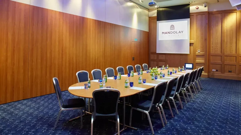 Warwick Room set with a single long boardroom table and a mounted screen