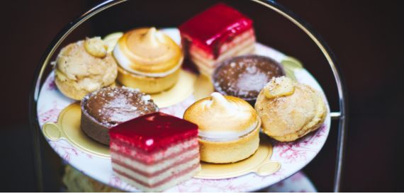 Afternoon tea stand with an assortment of tarts, meringues and layered cakes
