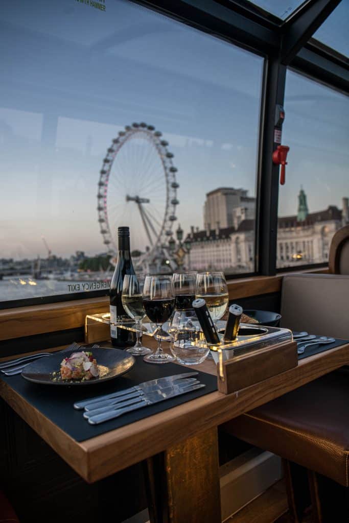 Upper deck window table set with wine glasses overlooking the London Eye