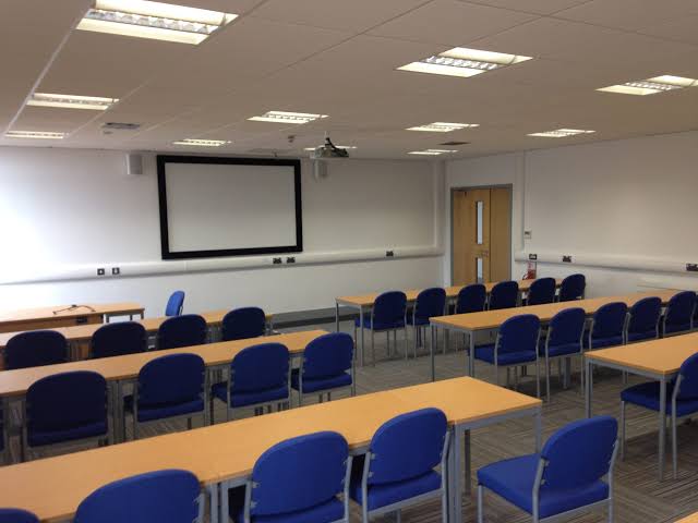 Weston Seminar Room set classroom-style with blue chairs and a screen