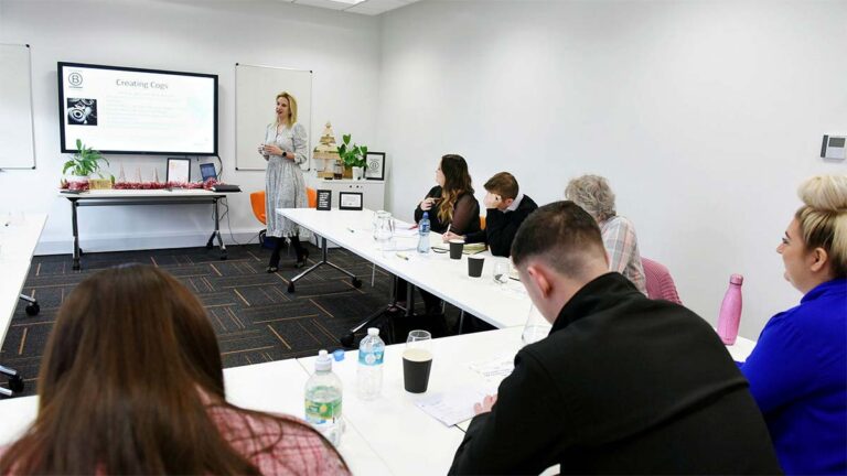 Fusion Hive training room with a presenter and delegates at a long table
