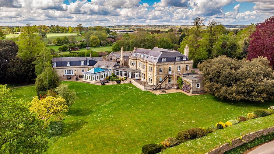 Aerial view of the manor house surrounded by lawns and gardens