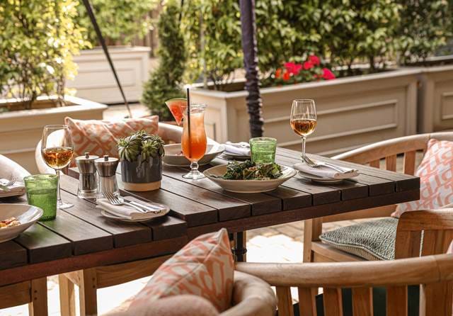 Outdoor terrace table set with cocktails and light dishes