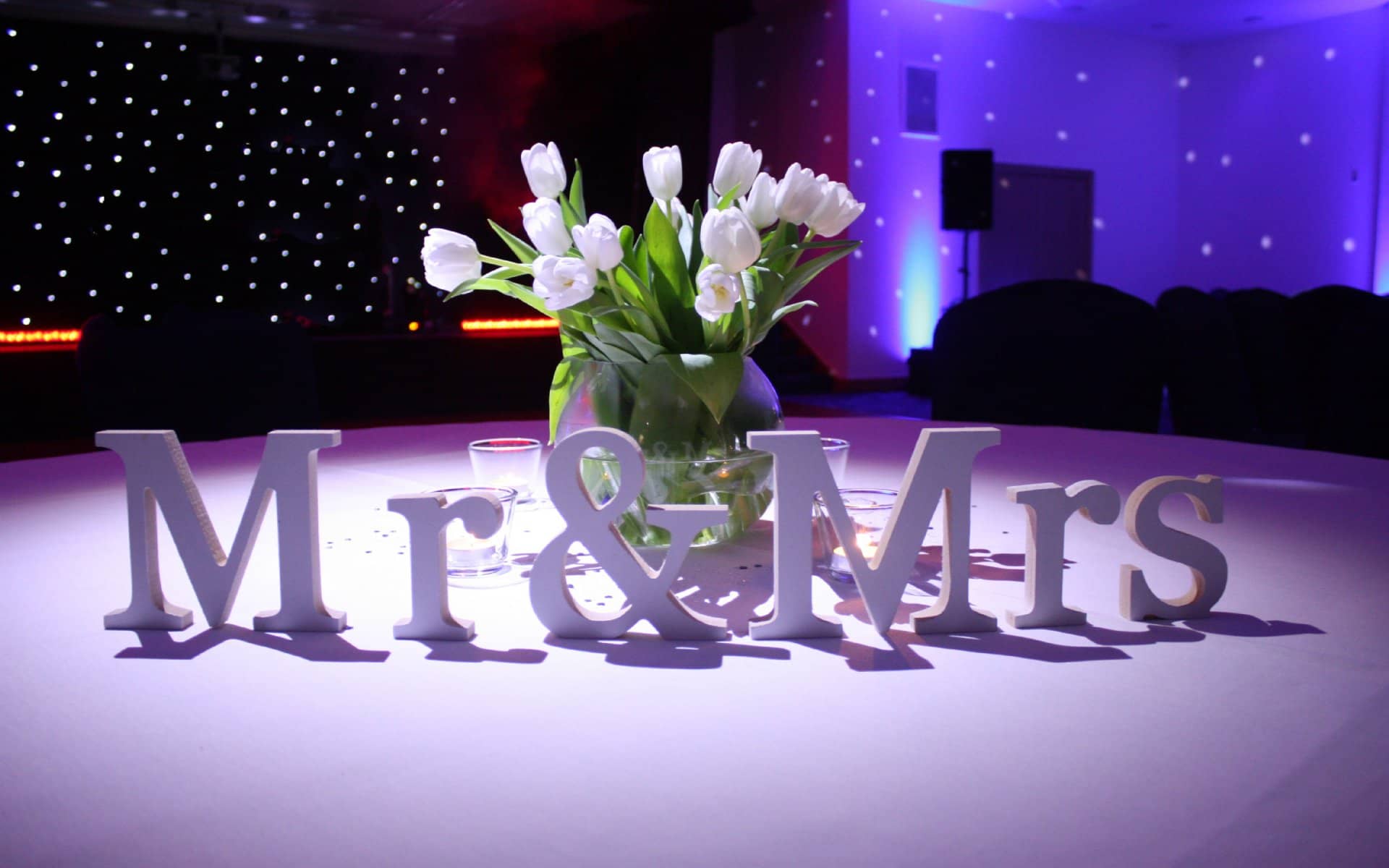 Table decoration reading Mr and Mrs beside white tulips and tea lights
