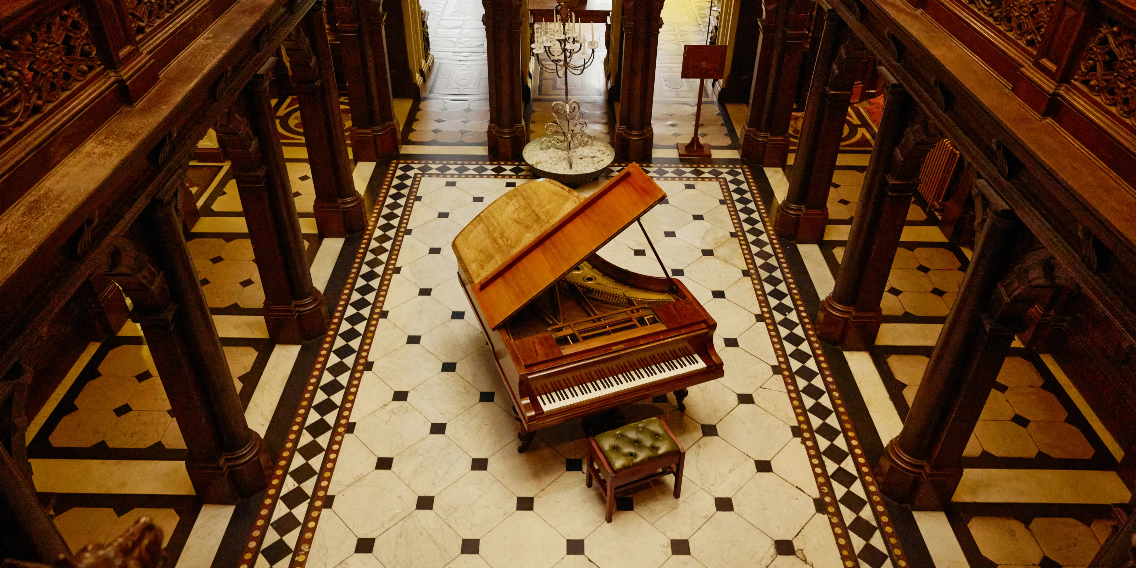 Grand hallway with black and white tiled floor and a piano