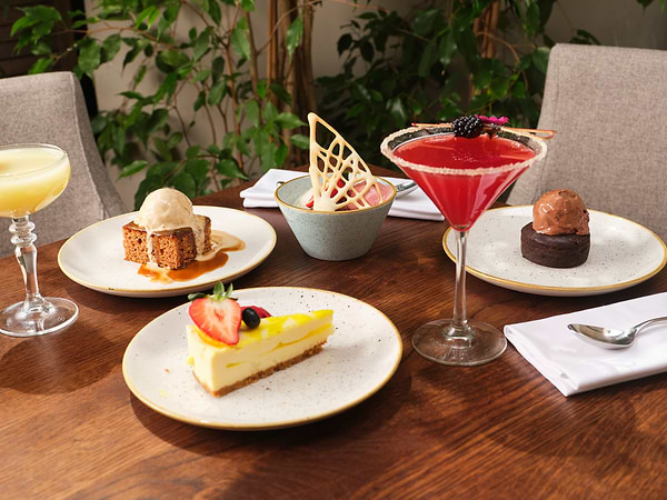 Selection of desserts and cocktails including cheesecake and chocolate torte