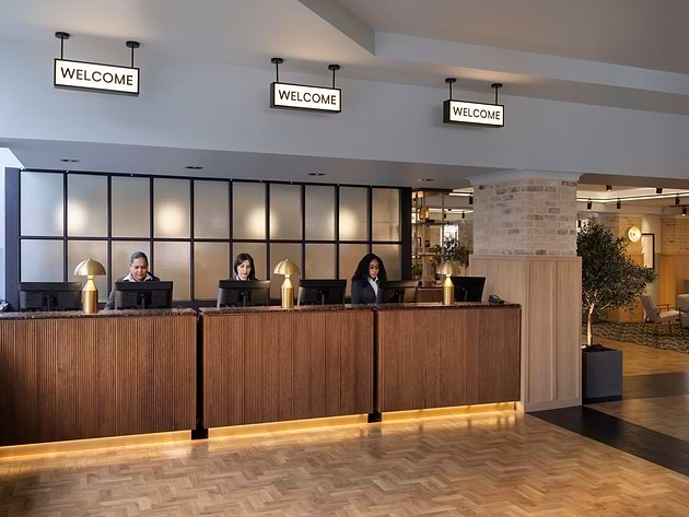 Hotel reception desk with staff at three welcome stations